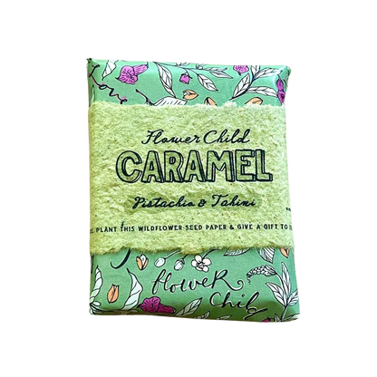 A packaged seed paper product labeled 'Flower Child Caramel Pistachio & Tahiti' with a light green textured center and mint green patterned top and bottom, shown on a plain white background.