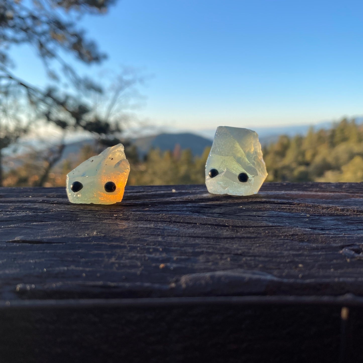 an assortment of rough gemstones with hand carved faces and black bead eyes.  Wax Apothecary