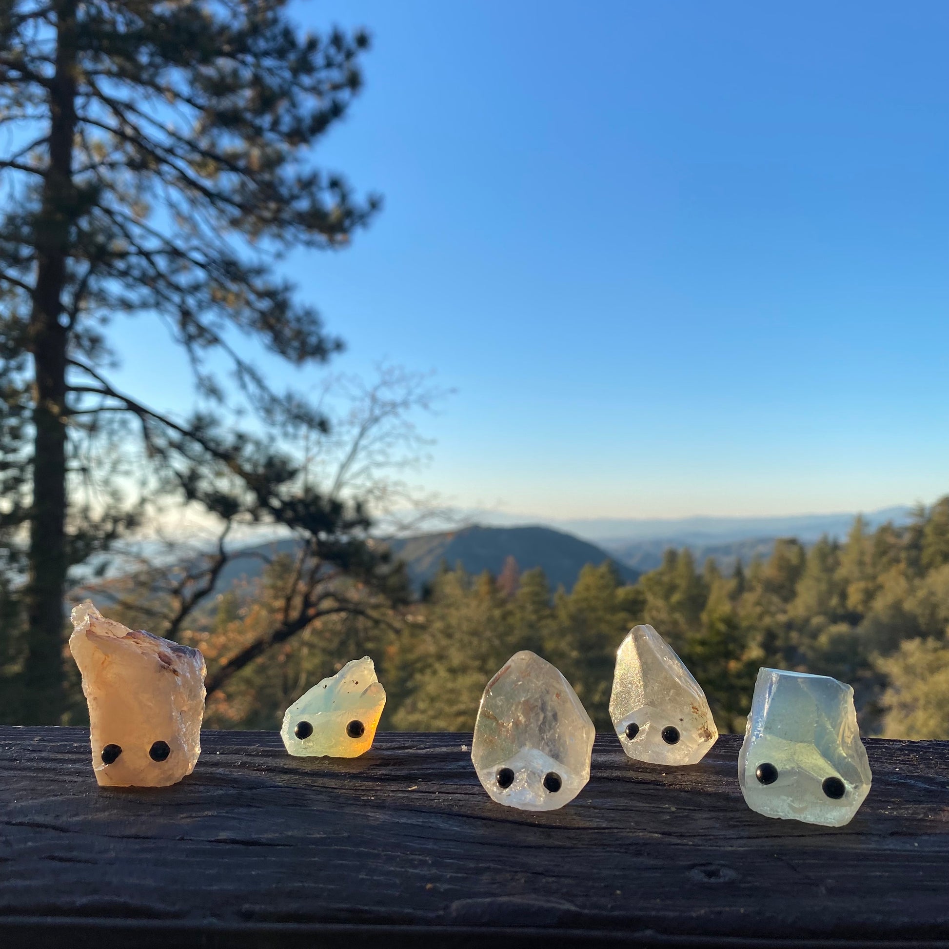 An assortment of rough cut gemstones with carved faces & black bead eyes.  Wax Apothecary